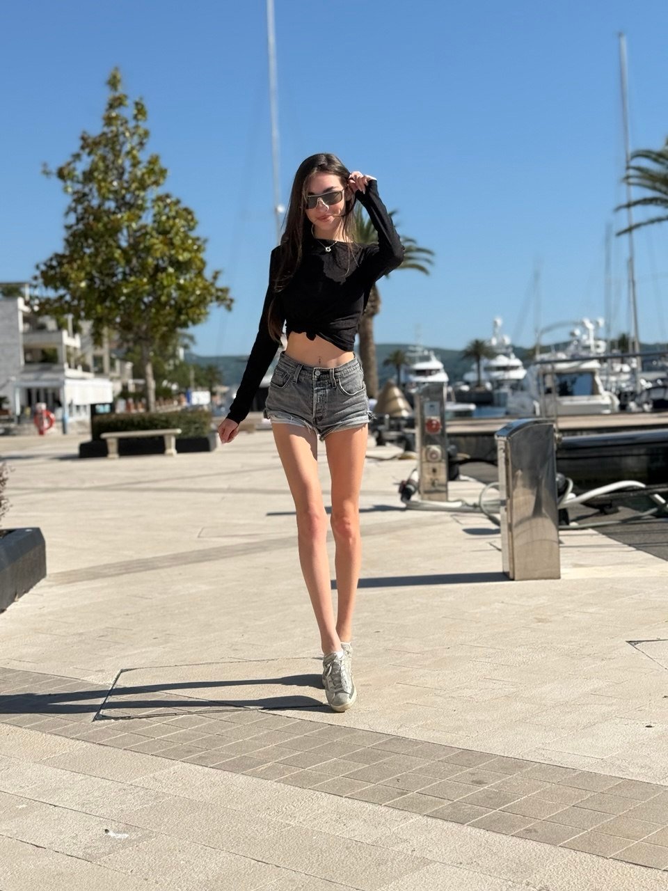 Anna Rey walking along the waterfront beside moored yachts